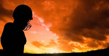 Siluet oyuncu spor miğfer karşı bulutlu gökyüzü günbatımı sırasında