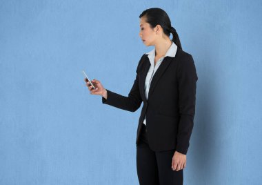 Mavi arka plan karşı akıllı telefon kullanarak iş kadını