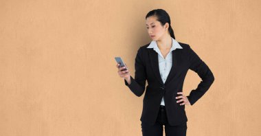 Bej renkli arka plan üzerinde cep telefonu kullanarak iş kadını