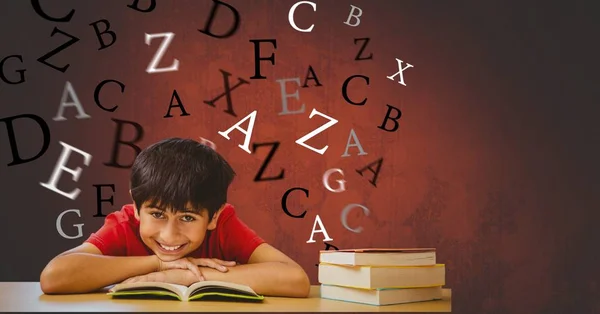 Niño con libro apoyado en la mesa —  Fotos de Stock