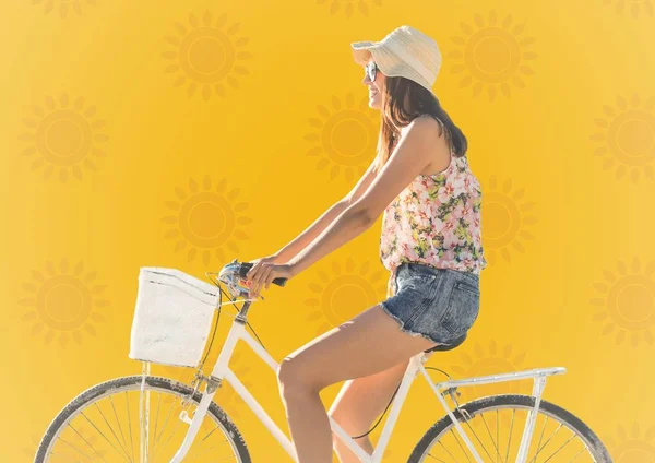 Woman on bike against yellow sun pattern — Stock Photo, Image