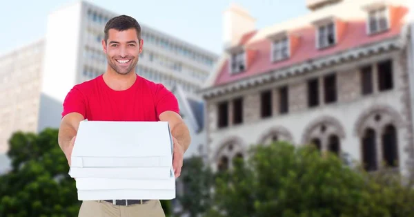 Zusteller hält Pizzakartons gegen Gebäude — Stockfoto