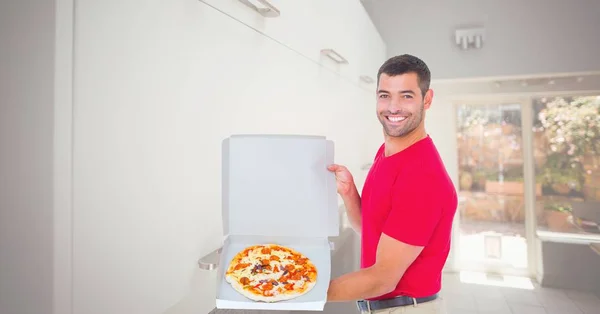 Человек показывает пиццу в коробке — стоковое фото