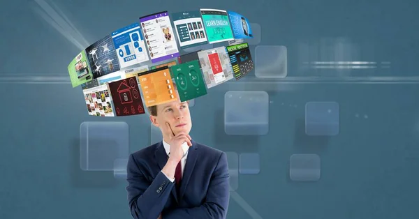 Businessman looking at various screens rotating over head — Stock Photo, Image