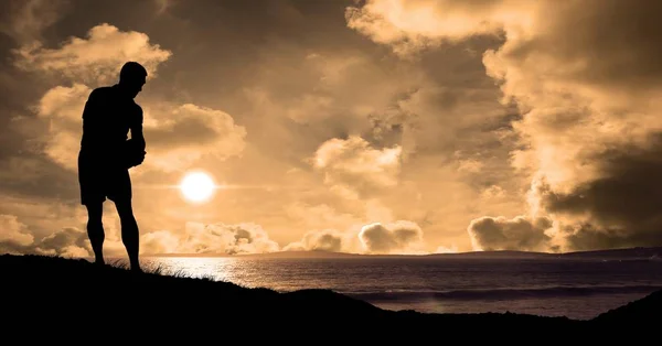 Sziluettjét sportoló során naplemente a strandon — Stock Fotó