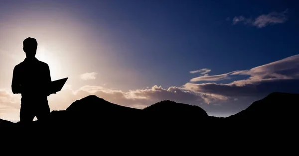 Sziluettjét üzletember használ laptop-hegyen során naplemente — Stock Fotó