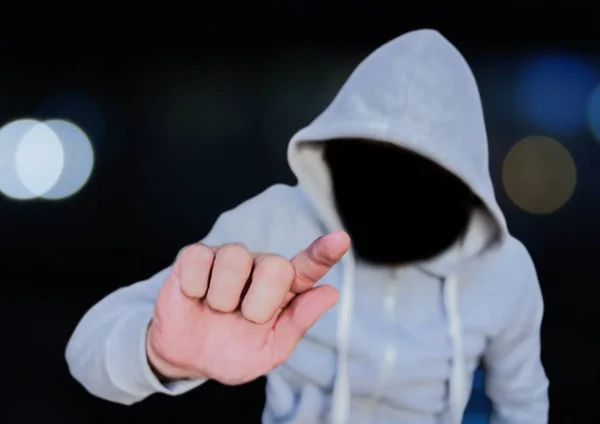 Homem criminoso anônimo no capuz em frente às luzes da cidade — Fotografia de Stock