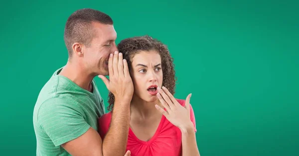 Susurrando pareja contra fondo verde — Foto de Stock