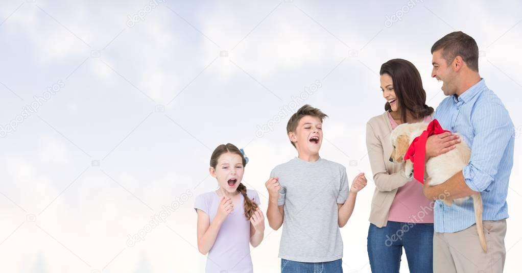 parents gifting puppy to children against sky