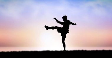 Gökyüzü karşı günbatımı sırasında egzersiz adam silüeti