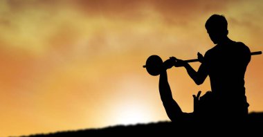 Adam barbell günbatımı sırasında kaldırma yardımcı eğitmen silüeti