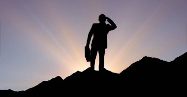 Dağ gökyüzü günbatımı sırasında ayakta siluet işadamı