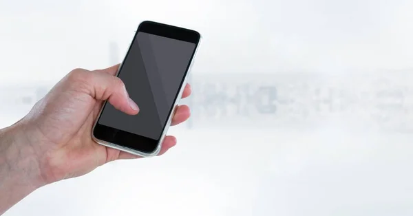 Mão com telefone contra skyline branco embaçado — Fotografia de Stock