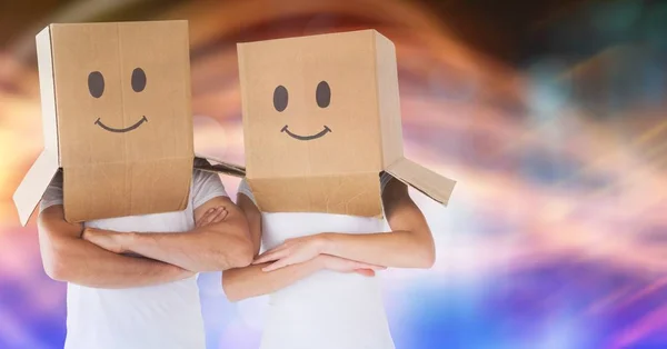 Пара с картонными коробками на голове с нарисованными на них улыбками — стоковое фото