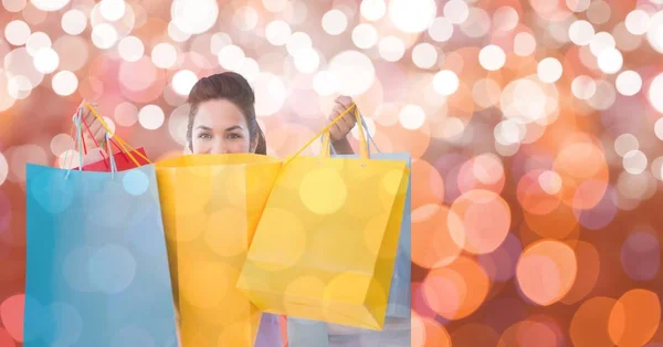 Vrouw houdt van boodschappentassen over bokeh — Stockfoto