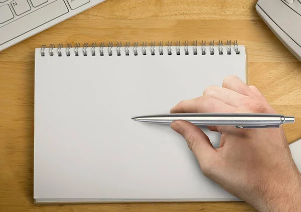 Hand med penna som skriver i anteckningar — Stockfoto