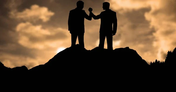 Бизнесмены силуэта держатся за руки на закате — стоковое фото