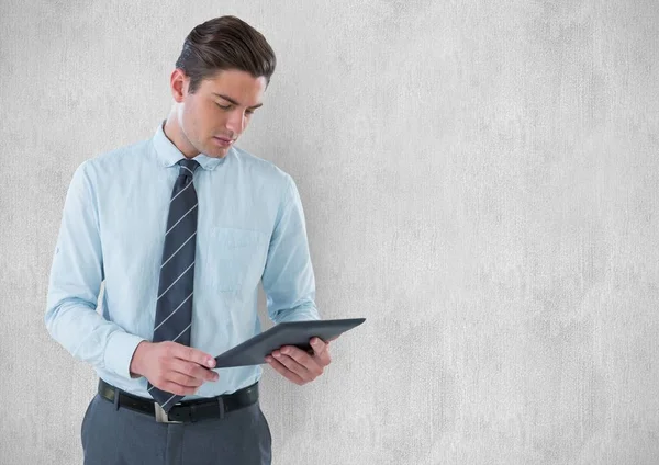 Jovem empresário segurando tablet digital contra parede — Fotografia de Stock