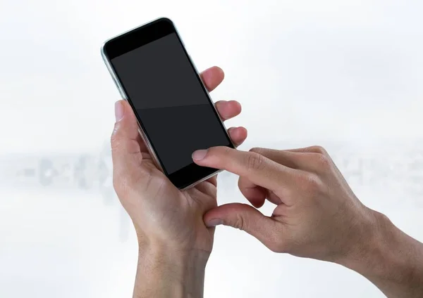 Mano con teléfono contra el horizonte blanco borroso — Foto de Stock