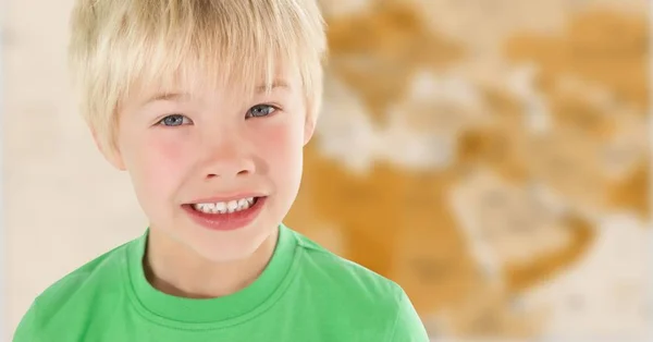 Junge lächelt gegen verschwommene braune Landkarte — Stockfoto