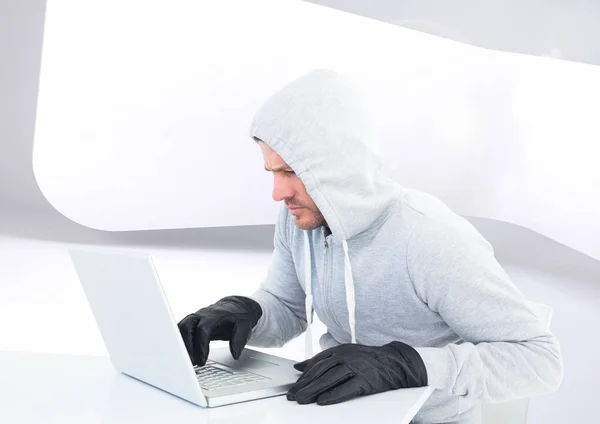Criminele Man in kap op laptop — Stockfoto