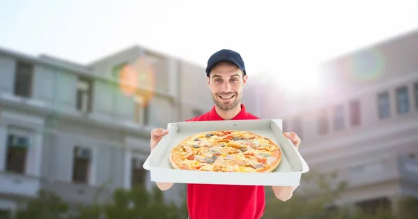 Entrega hombre mostrando pizza fuera de casa — Foto de Stock