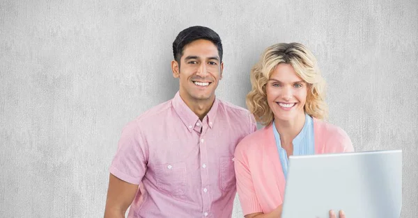 Smiling business people with laptop against wall — Stock Photo, Image
