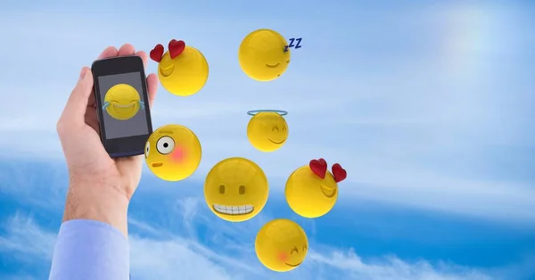 Emojis volando a mano usando un teléfono inteligente en el cielo — Foto de Stock