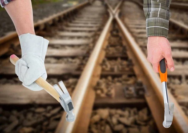 Hands with hammers in the railroad tracks — Stock Photo, Image