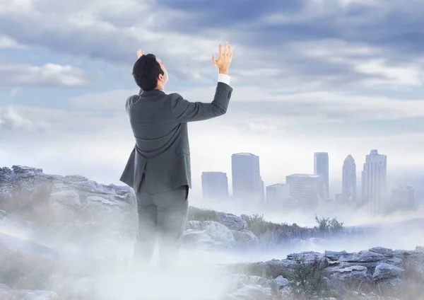 Hombre de negocios manos arriba en la montaña brumosa pico contra horizonte — Foto de Stock