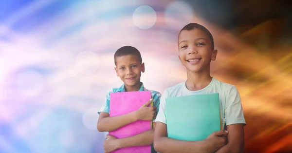 Niños de la escuela sosteniendo libros contra bokeh — Foto de Stock