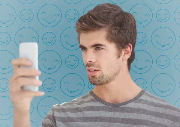 Homme avec téléphone contre emoji bleu — Photo