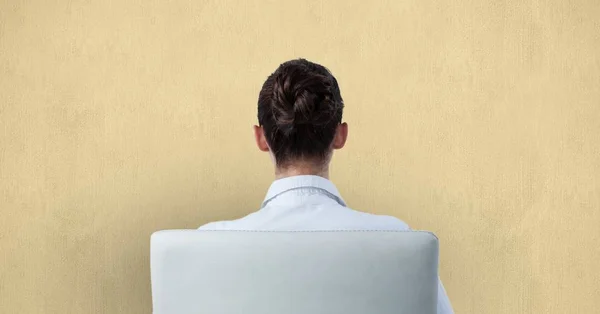 Vista trasera de la mujer de negocios sentada en la silla contra la pared — Foto de Stock