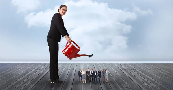 Mujer de negocios sonriente regando empleados — Foto de Stock