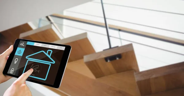 Τα χέρια, χρησιμοποιώντας έξυπνο σπίτι app στο Pc ταμπλετών με σκάλα στο παρασκήνιο — Φωτογραφία Αρχείου