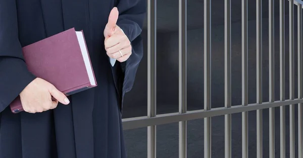 Судья держит книгу перед тюремной камерой — стоковое фото