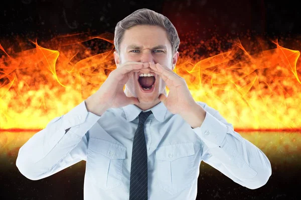 Сердитый бизнесмен кричит против огня — стоковое фото