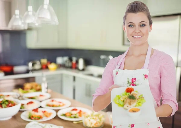 Mulher mostrando a placa na cozinha — Fotografia de Stock