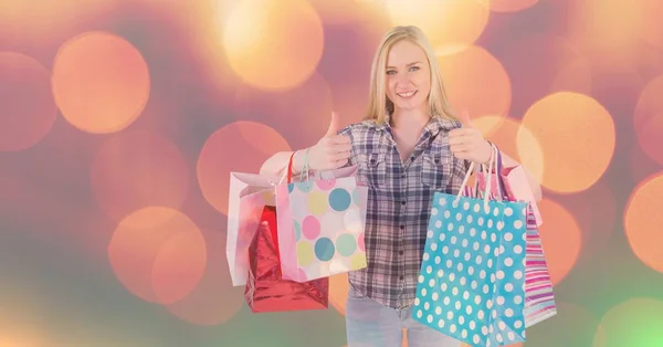 Mulher com sacos de compras mostrando polegares para cima gesto — Fotografia de Stock