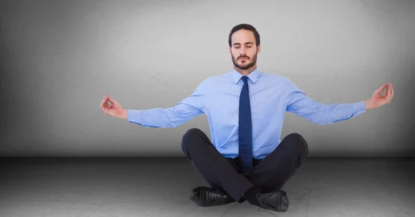 Forretningsmand mediterer mod grå væg - Stock-foto