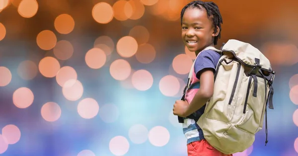 Achteraanzicht van buitenschoolse rugzak uitvoering over de bokeh — Stockfoto