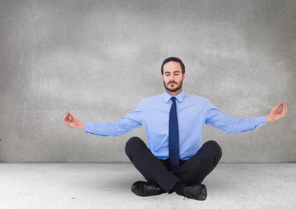 Hombre de negocios meditando en habitación gris —  Fotos de Stock