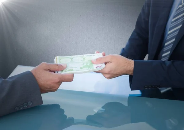 Бізнесмени обмінюються грошима за синім столом — стокове фото