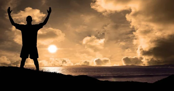 Silueta sportovec s rukama zvedl na pláži při západu slunce — Stock fotografie