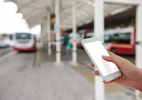 Hand met mobiel in het busstation — Stockfoto