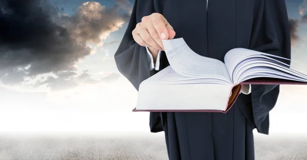 Суддя тримає книгу перед хмарами неба — стокове фото