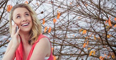 Cep telefonu kullanan gülümseyen kadın.