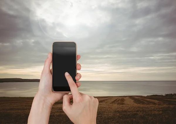 Mano que toca el teléfono móvil con el paisaje del cielo de la noche — Foto de Stock