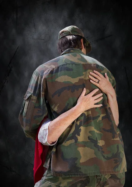 黒グランジ背景に抱きしめている兵士の裏 — ストック写真