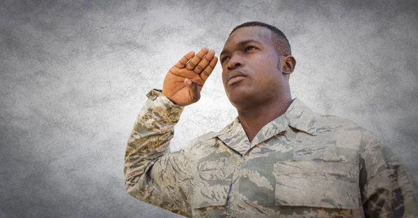 Soldier saluting against white wall — Stock Photo, Image